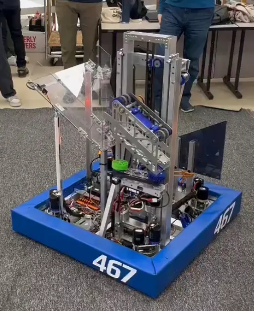 The finished 2025 robot with blue bumpers in the pits